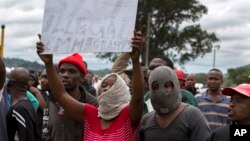 Des Sud-Africains brandissent des pancartes anti-immigration lors d'une manifestation à Pretoria, Afrique du Sud, 24 février 2017. 