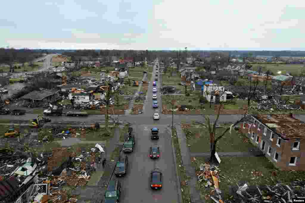 The funeral procession for corrections officer Robert Daniel passes a street lined with rubble and debris in Mayfield, Kentucky, Dec. 18, 2021. Officer Daniel was killed on Dec. 10 while directing workers and inmates, under his care, to safety following a devastating outbreak of tornadoes that ripped through several U.S. states.