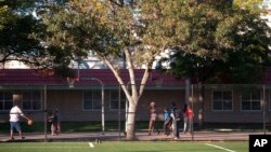 FILE - Youths play basketball at Currie Park in Minneapolis, near a large Somali community in the Cedar Riverside neighborhood, where the director of tadvocacy center says he's seen recruiters for terrorist groups approach kids in the park.