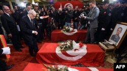 Tunisian President Beji Caid Essebsi decorates members from the presidential guards who were killed in a bomb blast on a bus in central Tunis the previous day during a ceremony at Carthage Palace, Tunis, Nov. 25, 2015. 