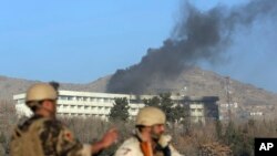 Petugas keamanan Afghanistan berdiri saat asap hitam mengepul dari Hotel Intercontinental, di Kabul, Afghanistan, pasca serangan, 21 Januari 2018.