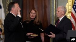 Wakil Presiden AS Mike Pence (kanan) mengambil sumpah Direktur CIA Mike Pompeo (kiri), yang didampingi istrinya Susan, di Gedung Putih (23/1). (AP/Susan Walsh)