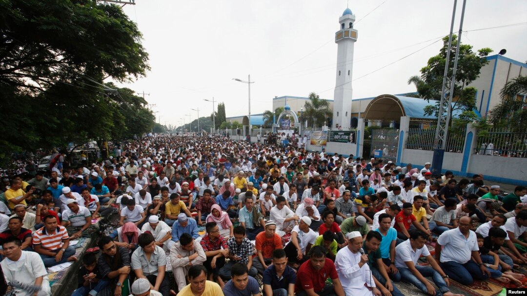 FILE - Thousands of Filipino Muslims take part in morning prayers during Eid al-Fitr celebration, marking the end of Ramadan, the holiest month in the Islamic calendar, along a road outside Blue Mosque in Taguig, Metro Manila, August 9, 2013.
