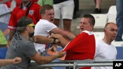 FILE - Russian supporters attack an England fan at the end of the Euro 2016 Group B soccer match between England and Russia, at the Velodrome stadium in Marseille, France, June 11, 2016.