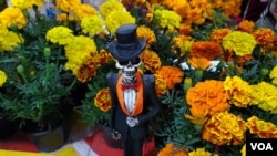 Un catrín con flores de muerto en un puesto de mercado en Ciudad de México el 31 de octubre de 2023, previo a la celebración del Día de los Muertos, una fiesta cultural que se posiciona también como oportunidad de negocios. [Foto: Tomás Guevara, VOA].