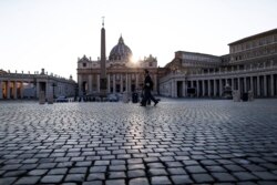 FILE - Police officers patrol an empty St. Peter's Square at the Vatican, April 10, 2020.