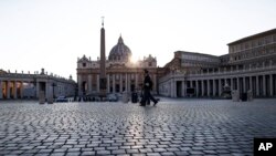 Police officers patrol an empty St. Peter's Square at the Vatican, Friday, April 10, 2020. Pope Francis began the Good Friday service at the Vatican with the Passion of Christ Mass and hours later will preside over the traditional Way of the Cross…