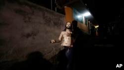 ARCHIVO - Un hombre lleva parte de una estatua de Jesús de Nazaret a una iglesia después de que fue exhibida en una procesión de Semana Santa en Puellaro, Ecuador, el martes 31 de marzo de 2015.