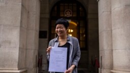 Wartawan Hong Kong pemenang penghargaan, Bao Choy, menunjukkan keputusan tertulis Pengadilan Banding Akhir kepada anggota pers setelah dibebaskan oleh pengadilan tinggi kota di Hong Kong, Senin, 5 Juni 2023. (AP/Louise Delmotte)