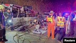 Rescue personnel work to retrieve casualties from an overturned bus, after it lost control and fell into a ditch during its journey from Bueng Kan to Rayong, in Prachinburi province, Thailand, Feb. 26, 2025. (Prachinburi Highway District /Handout via REUTERS)