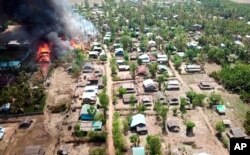 FILE - A fire burns in the predominantly ethnic Rakhine village of Let Kar in Rakhine State's Mrauk-U township, western Myanmar, May 16, 2020.