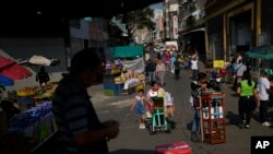 Foto de archivo. Varias personas caminan cerca de un mercado en Caracas, Venezuela. (Foto AP/Ariana Cubillos)