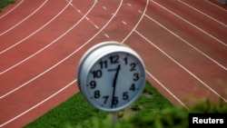 FILE - A running track is seen through a clock tower near the construction site of the New National Stadium, the main stadium for the Tokyo 2020 Olympics and Paralympics, in Tokyo, Japan, Aug. 6, 2018. 