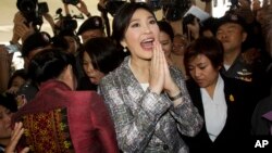 Thailand's former Prime Minister Yingluck Shinawatra, center, leaves parliament in Bangkok, Thailand, Thursday, Jan. 22, 2015.