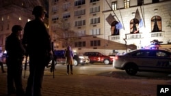 Policía de la Ciudad de Nueva York, fuertemente armados, hacen guardia frente al consulado francés en la Quinta Avenida.