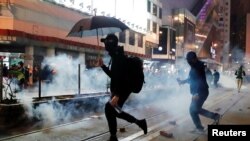 Manifestantes prodemocracia en Hong Kong huyen de gases lacrimógenos lanzados por la policía durante una marcha el Día de Año Nuevo el 1 de enero de 2020.