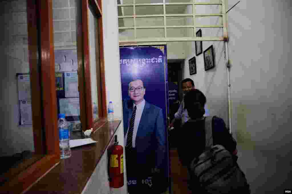 A portrait of former CNRP&rsquo;s President Sam Rainsy is displayed at the main gate of the party&rsquo;s headquarters as VOA journalists pass by during the election night of June 2, 2017. Mr. Rainsy once announced that the June 4 commune elections results could lead his return from exile. (Aun Chhengpor/VOA Khmer)
