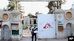 Christopher Stokes, second left, the general director of Doctors Without Borders stands at the gate of its hospital after U.S. troops left the area in Kunduz, Afghanistan, October 15, 2015. 