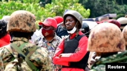 Ugandan opposition presidential candidate Robert Kyagulanyi, also known as Bobi Wine, is escorted by policemen during his arrest in Kalangala in central Uganda, Dec. 30, 2020. 