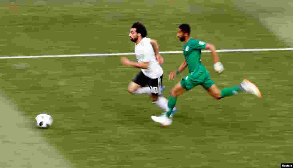 Mchezaji wa Misri Mohamed Salah wakishindana kuchukua mpira na mchezaji wa Saudi Arabia&#39;s Salman Al-Faraj.