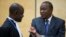 Kenya's President Uhuru Kenyatta (R) speaks to a member of his defense team as he appears before the International Criminal Court at The Hague, Oct. 8, 2014.
