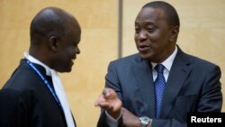 Kenya's President Uhuru Kenyatta (R) speaks to a member of his defense team as he appears before the International Criminal Court at The Hague, Oct. 8, 2014.