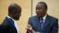 Kenya's President Uhuru Kenyatta (R) speaks to a member of his defense team as he appears before the International Criminal Court at The Hague, Oct. 8, 2014.