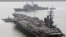 FILE - U.S. aircraft carrier USS Ronald Reagan anchors as U.S. Aegis Ship passes after they arrive at Busan port for joint military exercises in Busan, South Korea. The United States and South Korea started joint naval exercises, Nov. 11, 2017, that will involve three U.S. aircraft carriers in what military officials describe as a clear warning to North Korea.