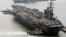 FILE - U.S. aircraft carrier USS Ronald Reagan anchors as U.S. Aegis Ship passes after they arrive at Busan port for joint military exercises in Busan, South Korea. The United States and South Korea started joint naval exercises, Nov. 11, 2017, that will 
