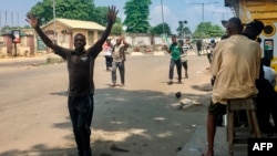 Les gens sont obligés de marcher les mains sur la tête lorsqu'ils passent les points de contrôle de sécurité, au marché d'Obalende, Lagos, Nigéria, le 24 octobre 2020.