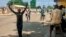 Les gens sont obligés de marcher les mains sur la tête lorsqu'ils passent les points de contrôle de sécurité, au marché d'Obalende, Lagos, Nigéria, le 24 octobre 2020.