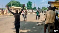 Les gens sont obligés de marcher les mains sur la tête lorsqu'ils passent les points de contrôle de sécurité, au marché d'Obalende, Lagos, Nigéria, le 24 octobre 2020.