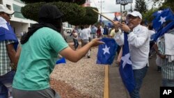 AUn miembro del Partido Nacional (derecha), se enfrenta a un manifestante antigubernamental durante una reunión para mostrar su apoyo a la reelección del presidente Juan Orlando, en Tegucigalpa, Honduras. Dic. 7, 2017.