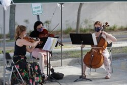 Un trío de músicos toca en una boda en Gainesville, Florida, tras permtirse los matrimonios como parte del levantamiento de las medidas por el coronavirus.