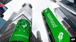 Electronic screens in New York's Times Square announce the Robinhood IPO, Thursday, July 29, 2021. Robinhood has already changed how people trade stocks and who's doing it. Now its sights are on the rest of the financial industry. (AP Photo/Mark…