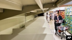 A shopper passes empty shelves at a Safeway grocery store on Nov. 18, 2021, in Alameda, Calif. 