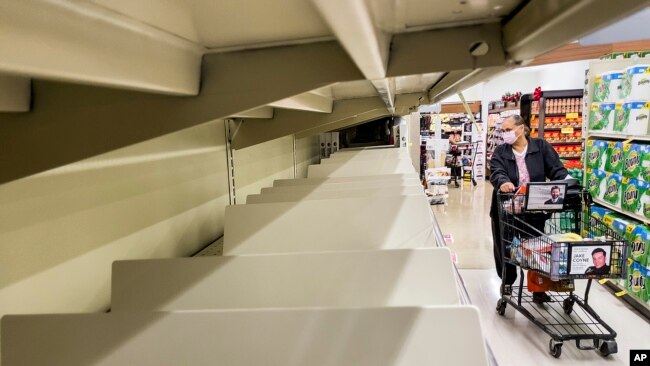 A shopper passes empty shelves at a Safeway grocery store on Nov. 18, 2021, in Alameda, Calif.