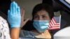 A U.S. immigration officer administers the oath as a swearing-in of newly naturalized United States citizens takes place in an empty parking lot during the outbreak of the coronavirus disease (COVID-19) in Santa Ana, California, July 29, 2020. 