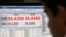 A currency trader works in front of a screen showing the value of the Indian rupee against the U.S. dollar on the floor of a trading firm in Mumbai, May 31, 2013. 