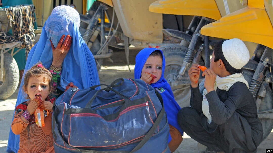 An Afghan family waits for transport upon their arrival into Pakistan at the Pakistan-Afghanistan border crossing point in Chaman on August 22, 2021, following the Taliban stunning takeover of Afghanistan. (Photo by AFP)