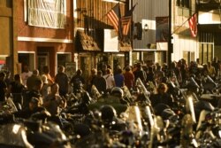 STURGIS, SD - AUGUST 08: People walk along Main Street during the 80th Annual Sturgis Motorcycle Rally in Sturgis, South Dakota on August 8, 2020. While the rally usually attracts around 500,000 people, officials estimate that more than 250,000…