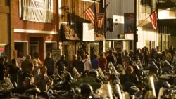 STURGIS, SD - AUGUST 08: People walk along Main Street during the 80th Annual Sturgis Motorcycle Rally in Sturgis, South Dakota on August 8, 2020. While the rally usually attracts around 500,000 people, officials estimate that more than 250,000…