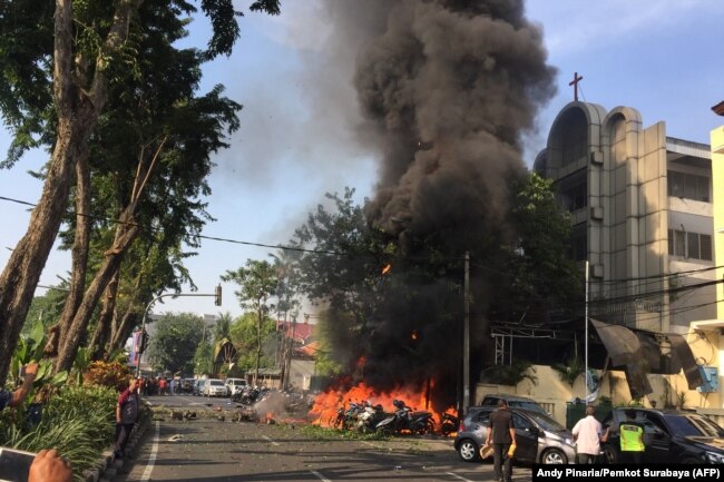 Polisi terlihat di lokasi ledakan di luar Gereja Pantekosta Pusat Surabaya. Serangkaian ledakan, termasuk setidaknya satu bom bunuh diri, melanda gereja-gereja di Tanah Air pada 13 Mei 2018, menewaskan sedikitnya 11 orang dan melukai puluhan lainnya, (Foto: AFP)