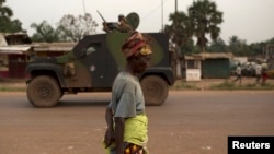 Seorang warga melewati tentara penjaga perdamaian dari Perancis di ibukota Bangui, Republik Afrika Tengah (4/2). (Reuters/Siegfried Modola)