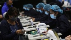 Petugas kesehatan berbicara dengan orang-orang yang akan divaksinasi COVID-19 Pfizer-BioNTech di Movistar Arena, Bogota, Kolombia, 16 Juni 2021. (REUTERS)