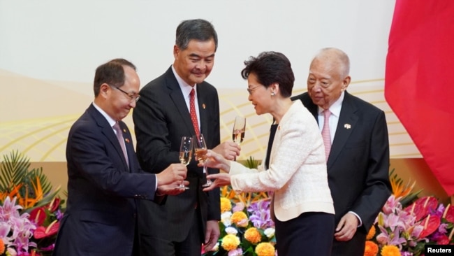 中联办主任王志民（左一）和香港特首林郑月娥（右二）2019年7月1日在庆祝香港主权移交22周年的庆典上。