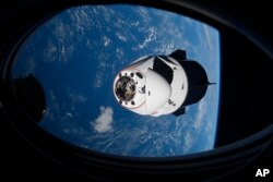FILE - In this April 24, 2021 photo made available by NASA, the SpaceX Crew Dragon capsule approaches the International Space Station.