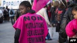 FILE - A woman wears a jersey reading "No to female genital mutilation" during a demonstration in Marseille, southern France, March 8, 2018.