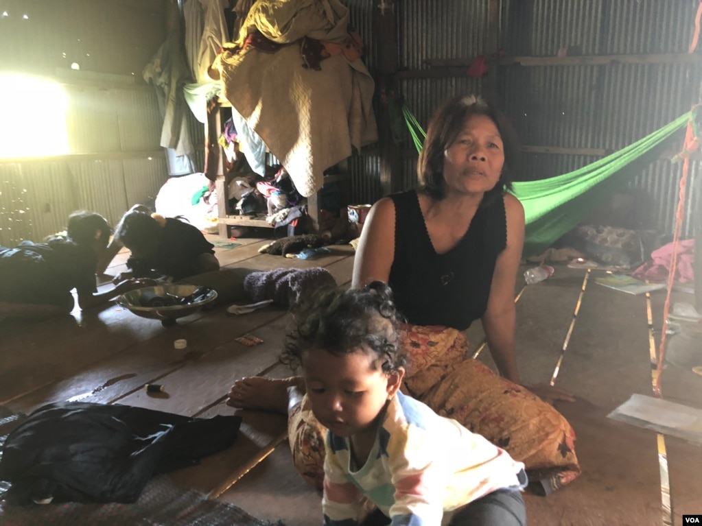 Om Samath, 53, a resident of Siem Reap City’s Chreav commune, looks after her grandchildren while their parents are at work. March 15, 2019. (Sun Narin/VOA Khmer)