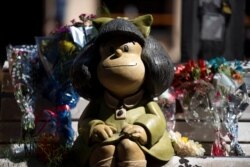 Se ven flores junto a una escultura del personaje cómico Mafalda, creada por el dibujante Joaquín Salvador Lavado, también conocido como Quino, quien falleció el miércoles 30 de septiembre de 2020 a los 88 años, en Buenos Aires.